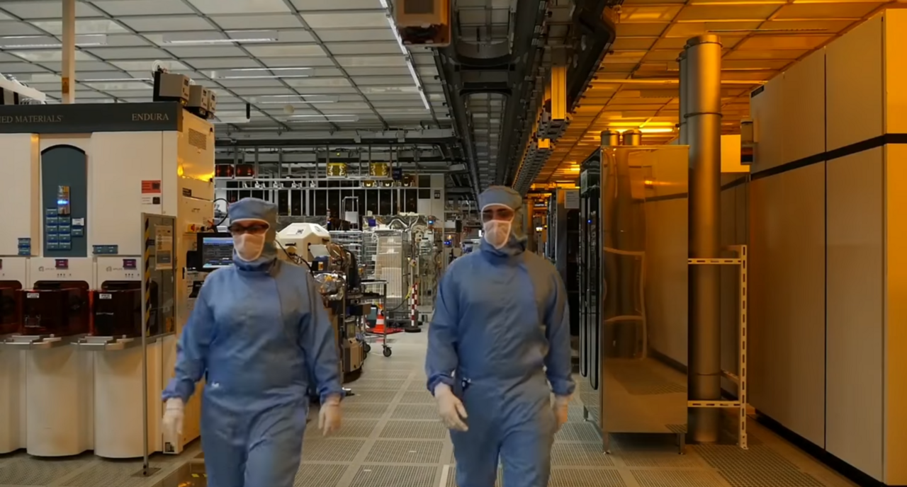 Reinraum in einer Halbleiterfabrik mit Beschäftigten in Schutzanzügen